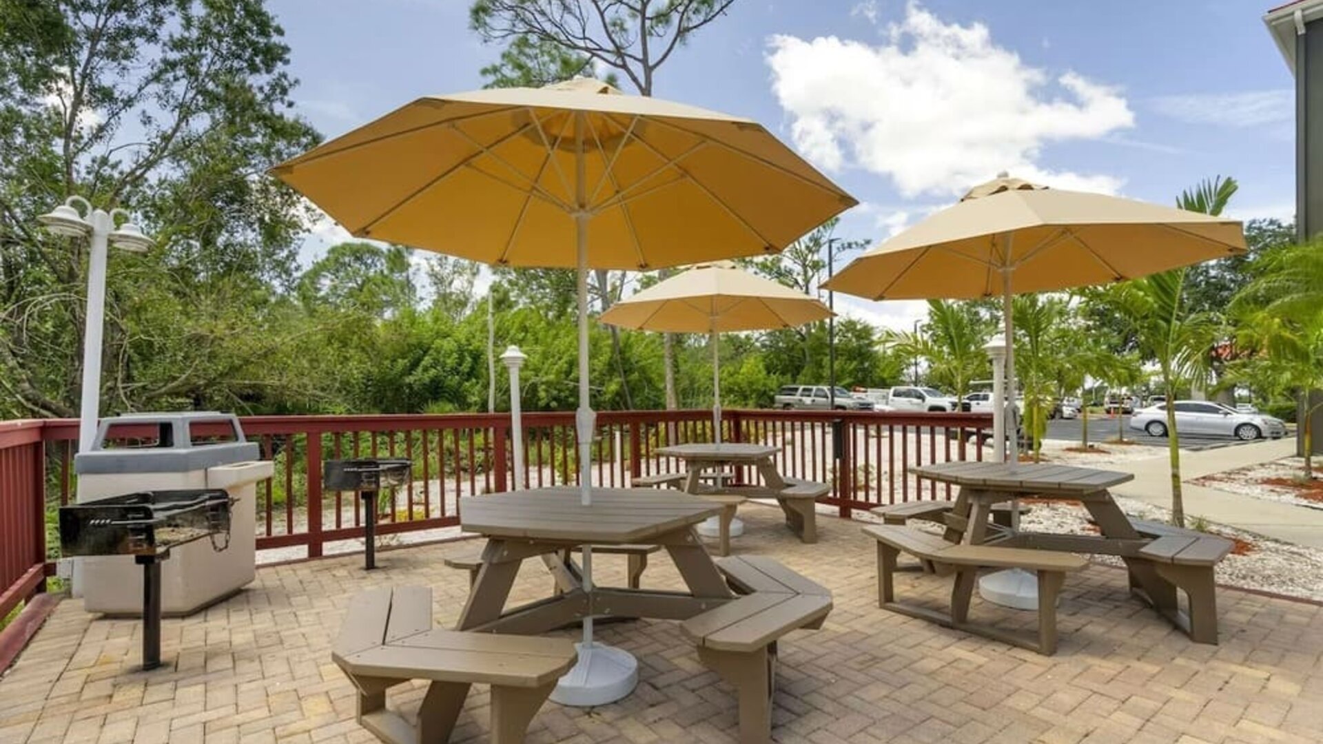 Outdoor picnic and barbecue area with shaded tables and tropical landscaping at Comfort Inn & Suites Port Charlotte-Punta Gorda.