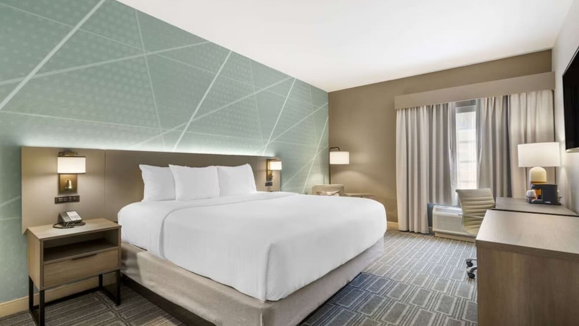 Contemporary king guest room with workspace, soft lighting, and modern décor at Comfort Inn & Suites Port Charlotte-Punta Gorda.