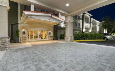 Covered hotel entrance illuminated at night with landscaped surroundings at Comfort Inn & Suites Port Charlotte-Punta Gorda.