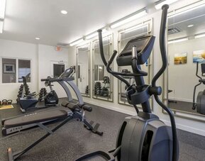 Well-equipped hotel gym with elliptical machines, treadmill, free weights, and mirrored workout space at Comfort Inn & Suites Port Charlotte-Punta Gorda.
