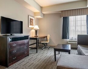 Studio-style suite with sofa seating, workspace, and flat-screen television at Comfort Inn & Suites Port Charlotte-Punta Gorda.