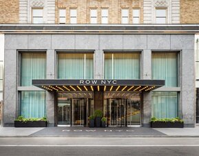 Main entrance façade of Row NYC featuring sleek urban architecture and illuminated signage in Midtown Manhattan.