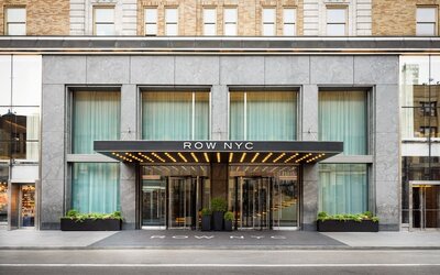 Main entrance façade of Row NYC featuring sleek urban architecture and illuminated signage in Midtown Manhattan.