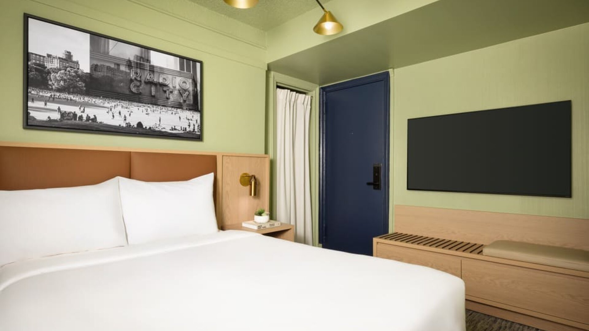 Contemporary guest room with minimalist furnishings, wall-mounted television, and modern city-inspired décor at Row NYC.