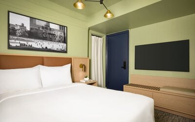 Contemporary guest room with minimalist furnishings, wall-mounted television, and modern city-inspired décor at Row NYC.