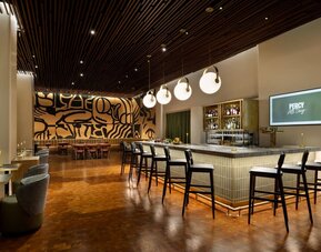 Sophisticated cocktail bar area with elegant seating, warm lighting, and artistic interior design at Row NYC.