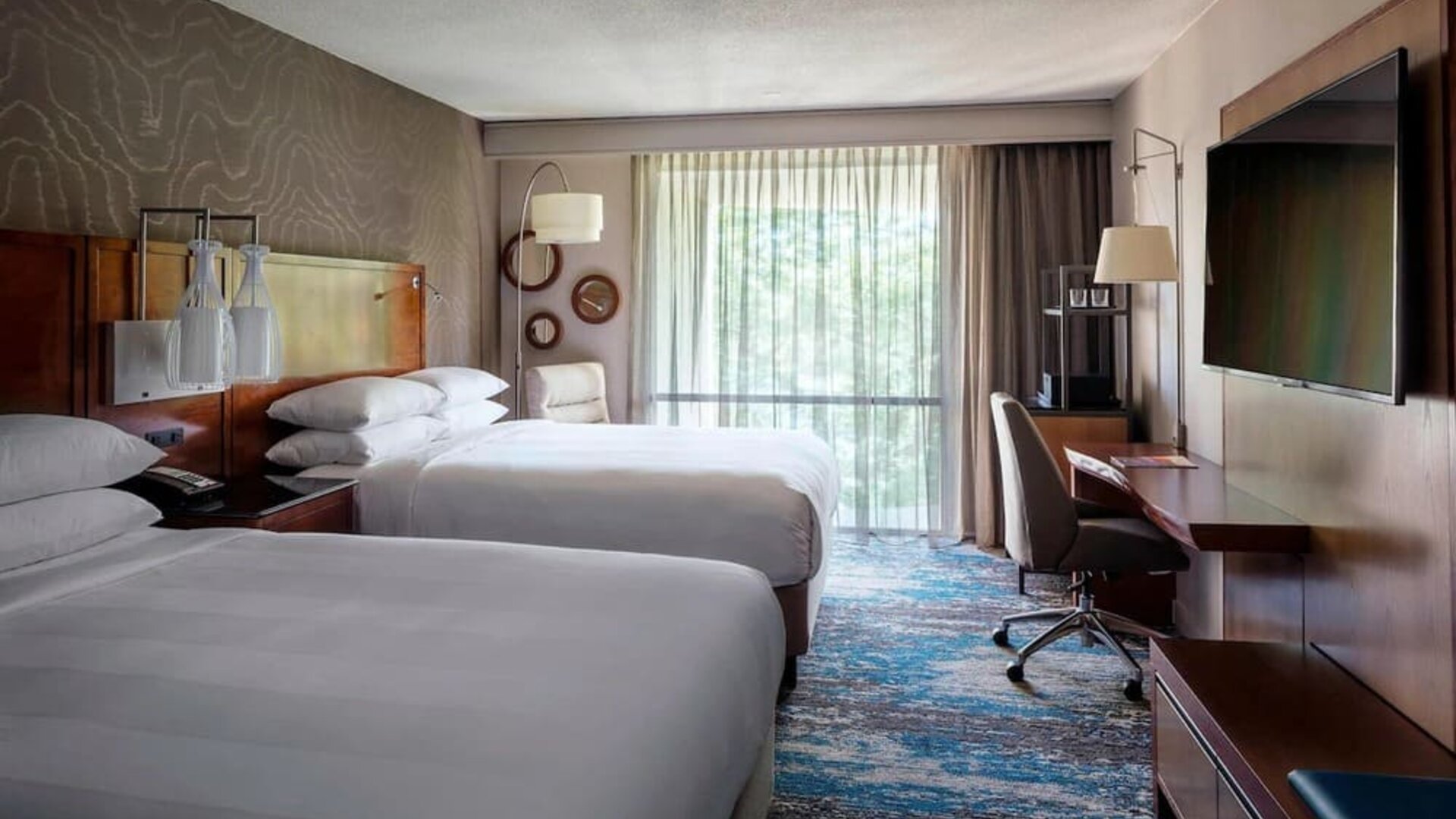 Contemporary double guest room with two comfortable beds, workspace, and large window views at Boston Marriott Newton.