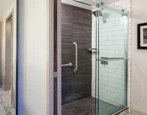 Modern glass-enclosed shower area with sleek tilework and contemporary bathroom design at Boston Marriott Newton.