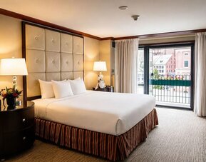 Elegant king guest room with plush bedding, spacious layout, and balcony views at The Bostonian Boston, A Millennium Hotel.