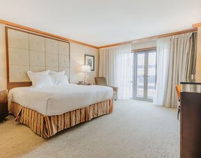 Bright king guest room featuring elegant décor, soft natural lighting, and contemporary furnishings at The Bostonian Boston, A Millennium Hotel.