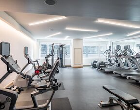 Bright and spacious fitness center equipped with cardio machines, free weights, and modern workout facilities at The Envoy Hotel, Autograph Collection.