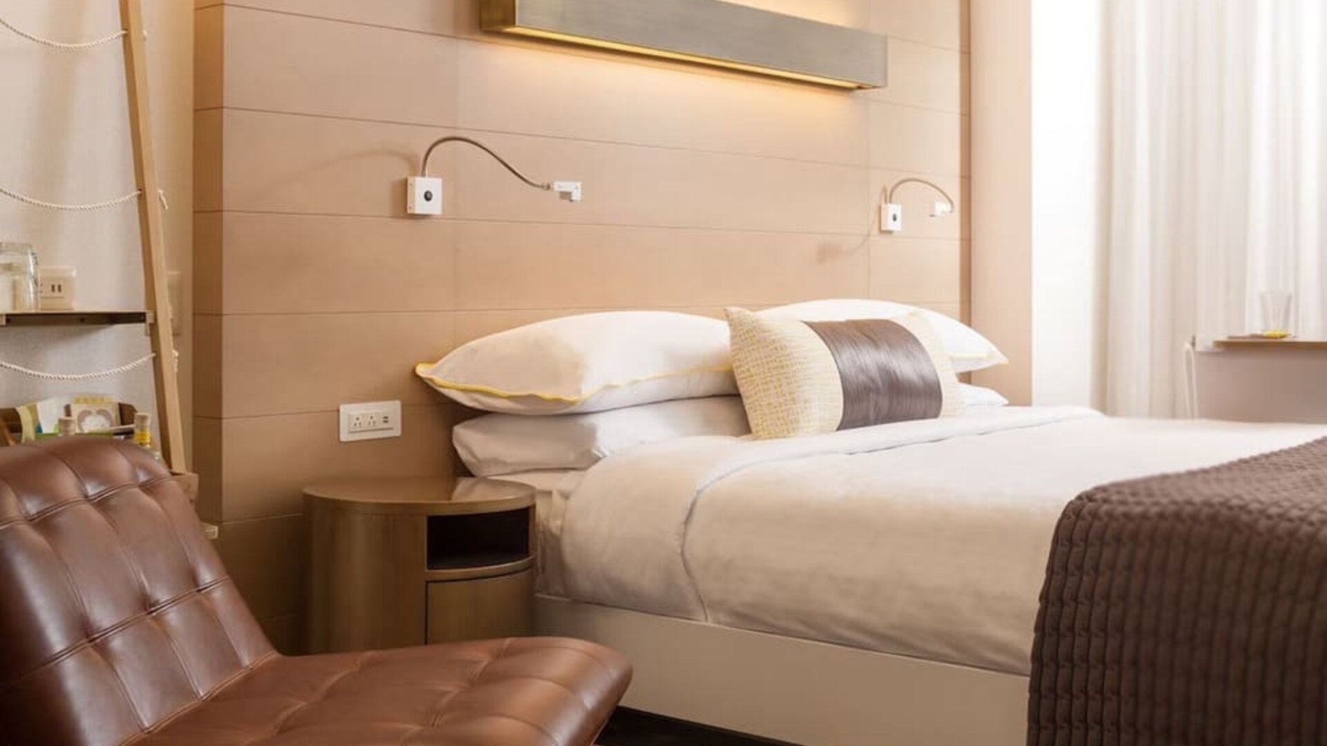 Contemporary king guest room featuring warm wood accents, plush bedding, and stylish modern furnishings at The Envoy Hotel, Autograph Collection.