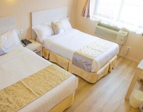 Comfortable twin-bed guest room with bright interiors and modern accommodations at Phoenix Hotel Brooklyn Sunset Park.