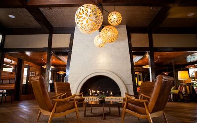 Cozy lobby fireplace lounge with modern lighting, leather seating, and warm communal gathering spaces at The Garland.
