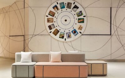 Modern lobby seating area showcasing artistic design elements, soft pastel furnishings, and a welcoming atmosphere for guests.