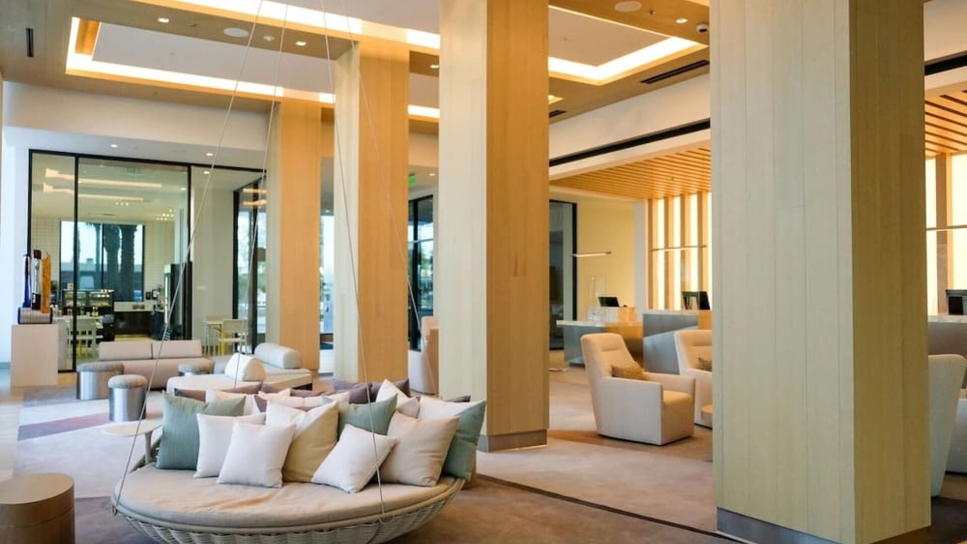 Grand lobby at The Viv Hotel, Anaheim, A Tribute Portfolio Hotel featuring high ceilings, elegant wood accents, lounge seating, and contemporary architectural design.