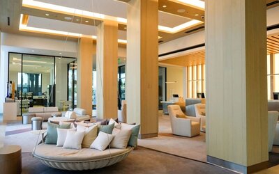 Grand lobby at The Viv Hotel, Anaheim, A Tribute Portfolio Hotel featuring high ceilings, elegant wood accents, lounge seating, and contemporary architectural design.