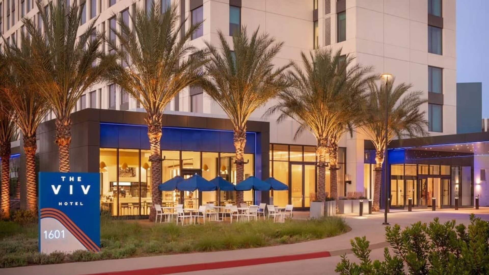 Exterior view of The Viv Hotel, Anaheim, A Tribute Portfolio Hotel showcasing its contemporary architecture, landscaped entrance, and welcoming arrival area.