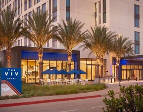Exterior view of The Viv Hotel, Anaheim, A Tribute Portfolio Hotel showcasing its contemporary architecture, landscaped entrance, and welcoming arrival area.
