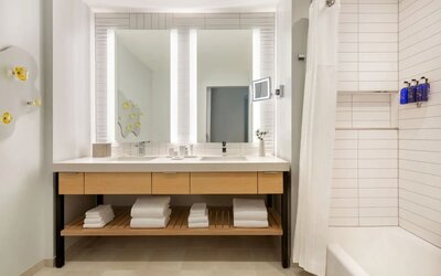 Guest bathroom with dual illuminated mirrors, spacious vanity, and modern bath amenities designed for comfort and convenience.