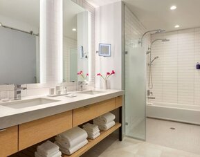 Large luxury bathroom with dual vanities, expansive mirrors, walk-in shower, soaking tub, and premium finishes designed for comfort and convenience.