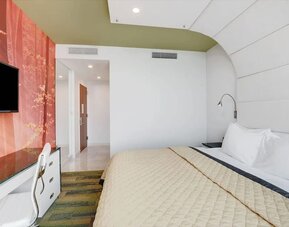 Stylish king bedroom with contemporary décor, plush bedding, work desk, flat-screen television, and thoughtfully designed interior finishes.