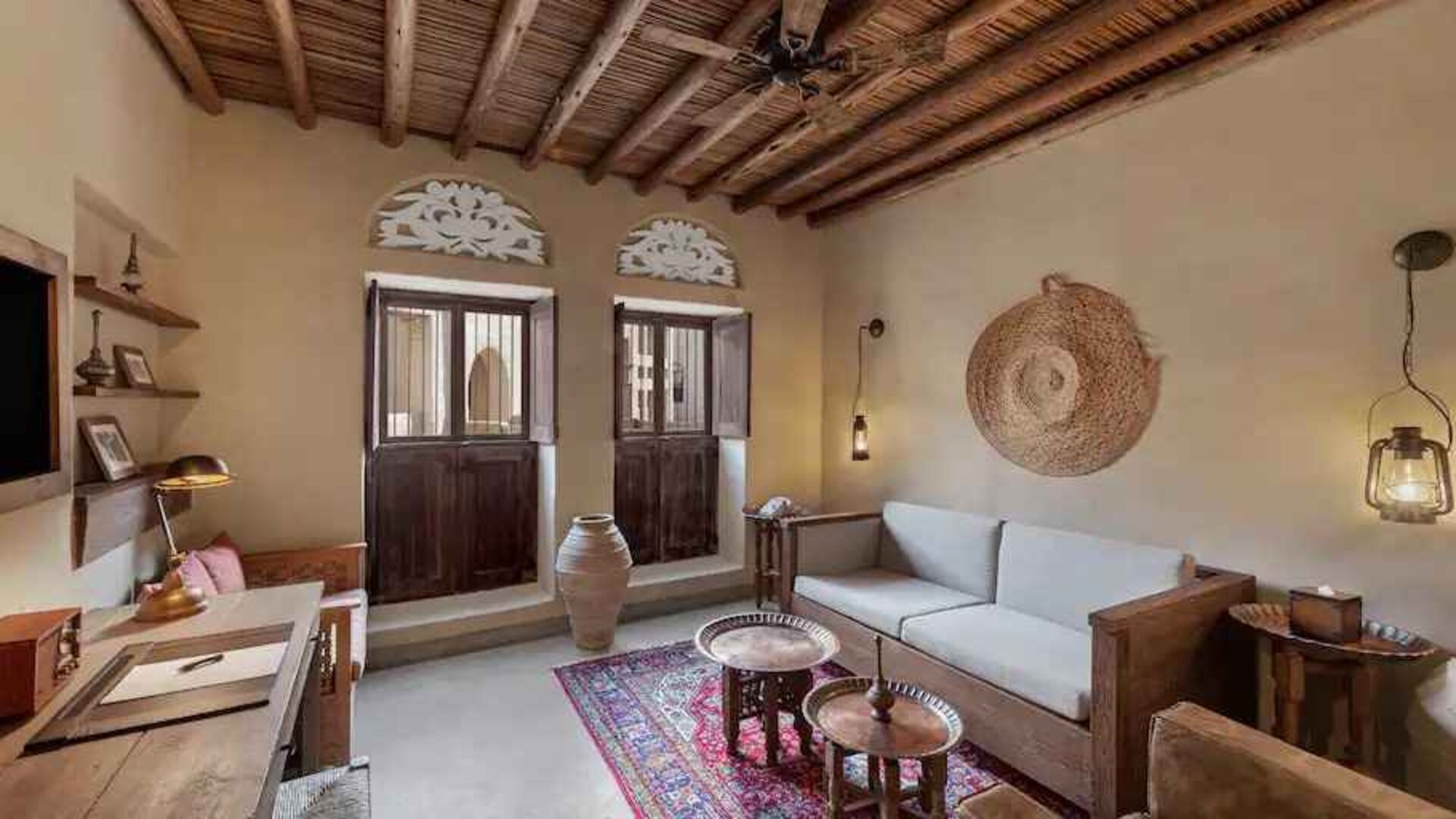 Spacious living room with sofa, TV screen and desk at the Al Seef Heritage Hotel Dubai, Curio Collection by Hilton.