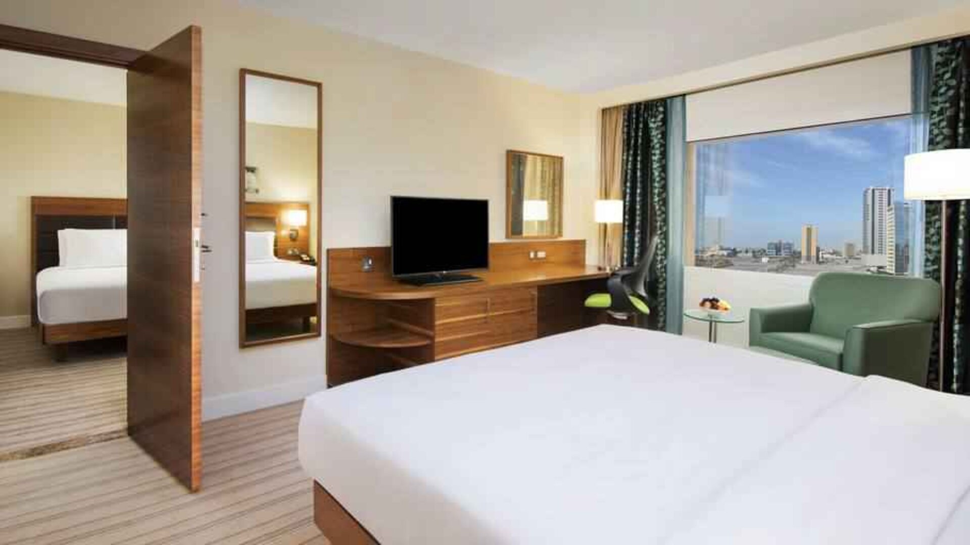 Comfortable queen room with window view and working desk at the Hilton Ras Al Khaimah Beach Resort.