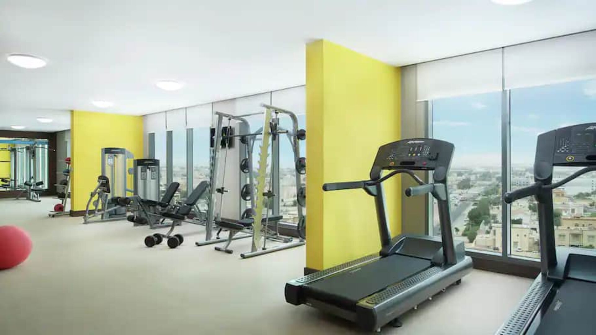Spacious gym with workout equipment and large windows