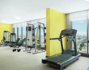 Spacious gym with workout equipment and large windows