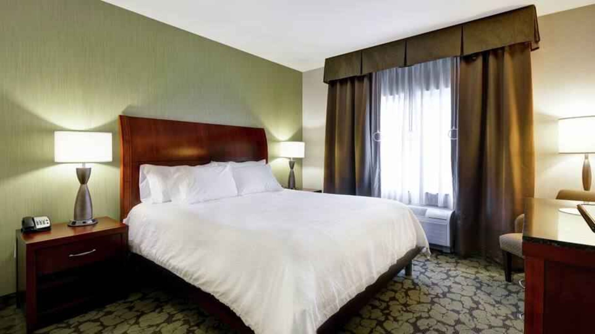 Comfortable king bed in a hotel bedroom at the Hilton Garden Inn Fort Collins.