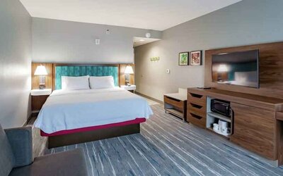 Comfortable king bed in a hotel room at the Hampton Inn Madison, OH.