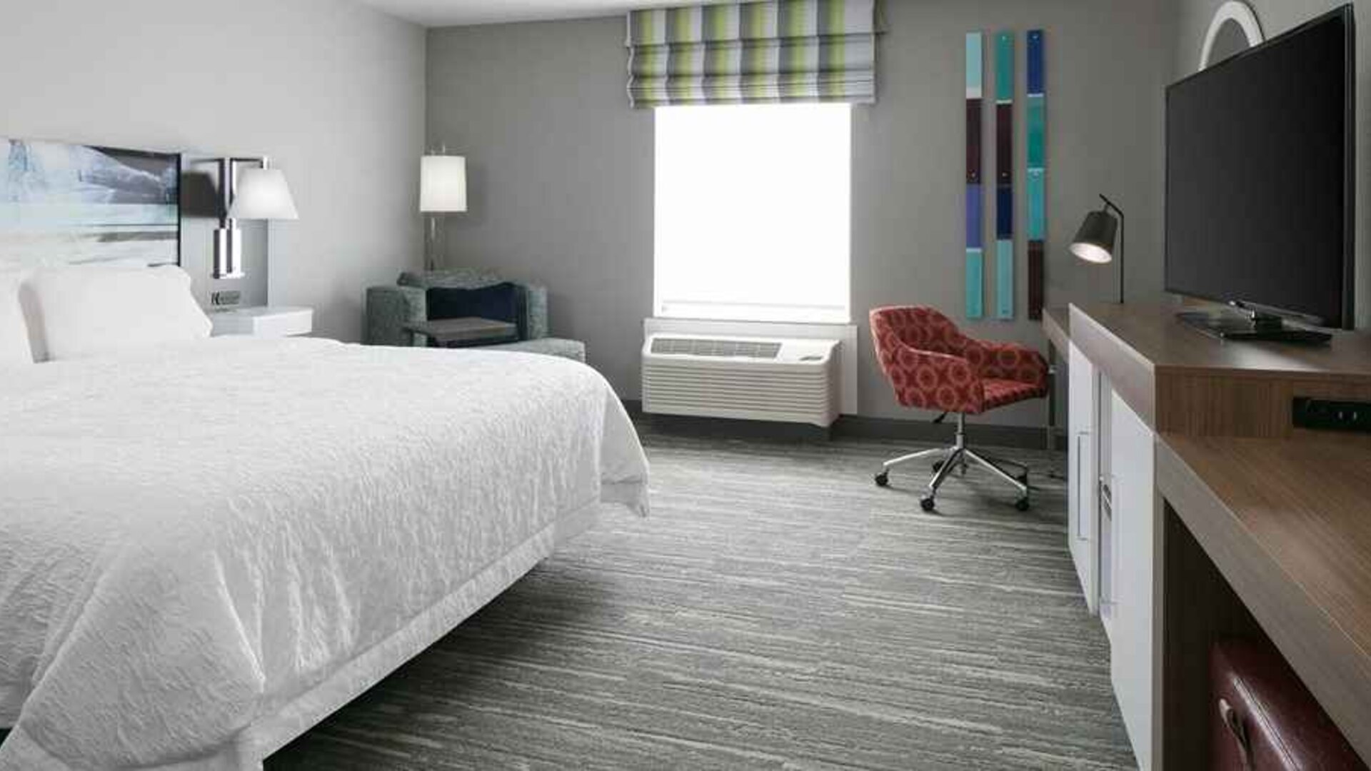 spacious king-sized room with TV and workspace at Hampton Inn Wichita Northwest.