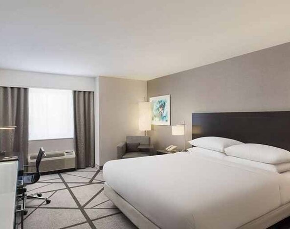 beautiful, luxury king suite with work desk and natural light at DoubleTree by Hilton Los Angeles - Norwalk.