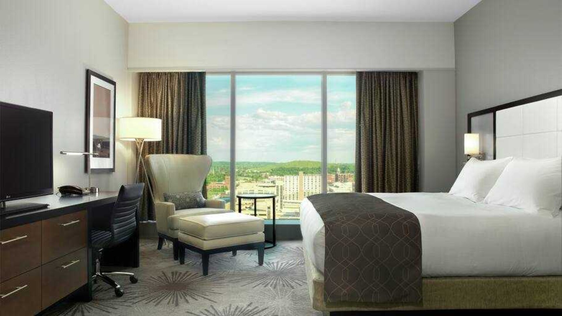 Beautiful king room with king size bed, TV screen, desk and windows at the DoubleTree by Hilton Cedar Rapids Convention Complex.