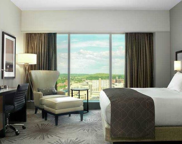 Beautiful king room with king size bed, TV screen, desk and windows at the DoubleTree by Hilton Cedar Rapids Convention Complex.