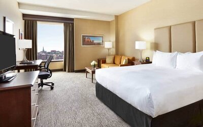King room with 1 king bed, work desk and view of downtown at the Hilton Saint John.