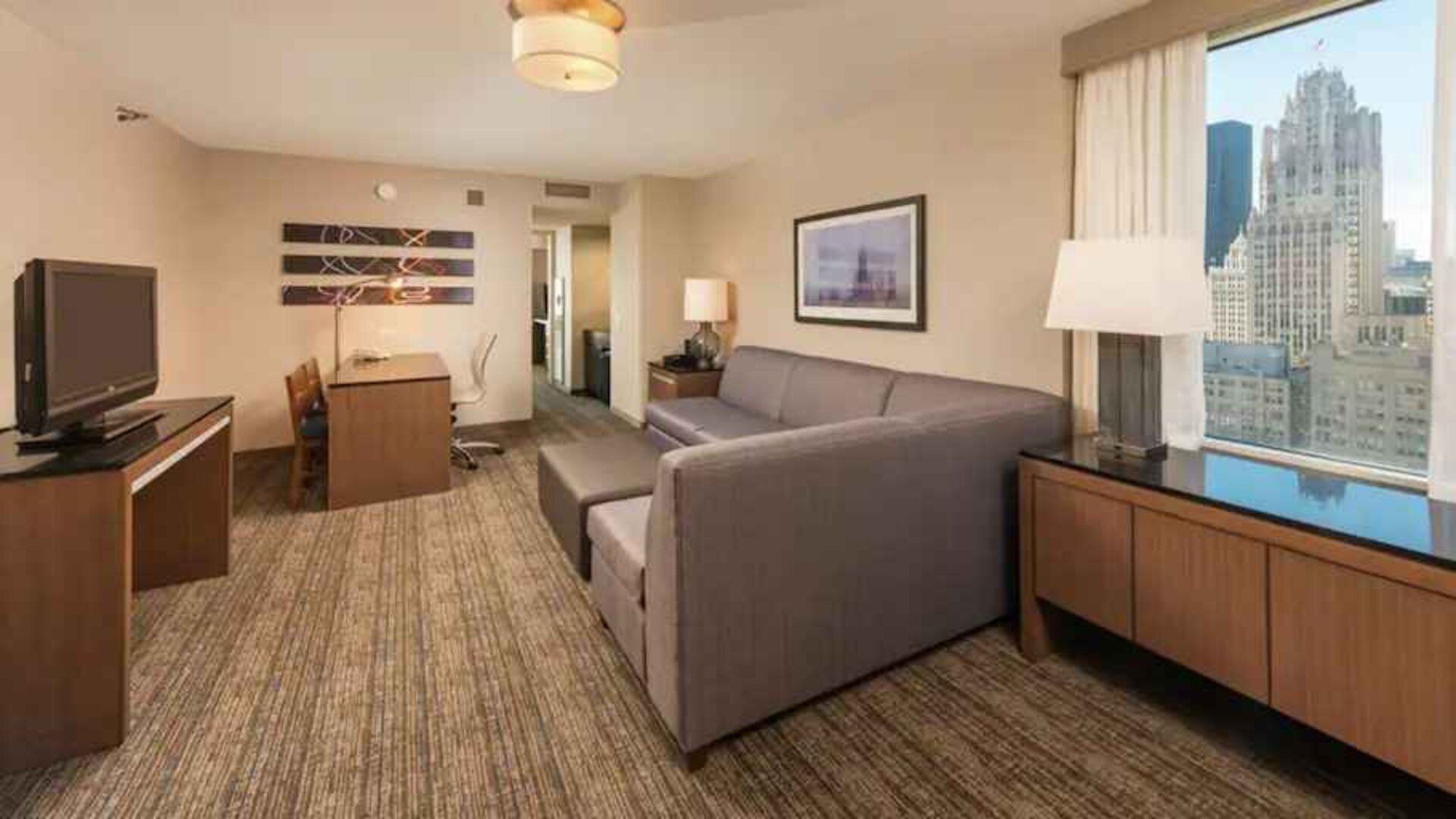 Spacious living room with working station in a king suite at the Embassy Suites by Hilton Chicago Magnificent Mile.