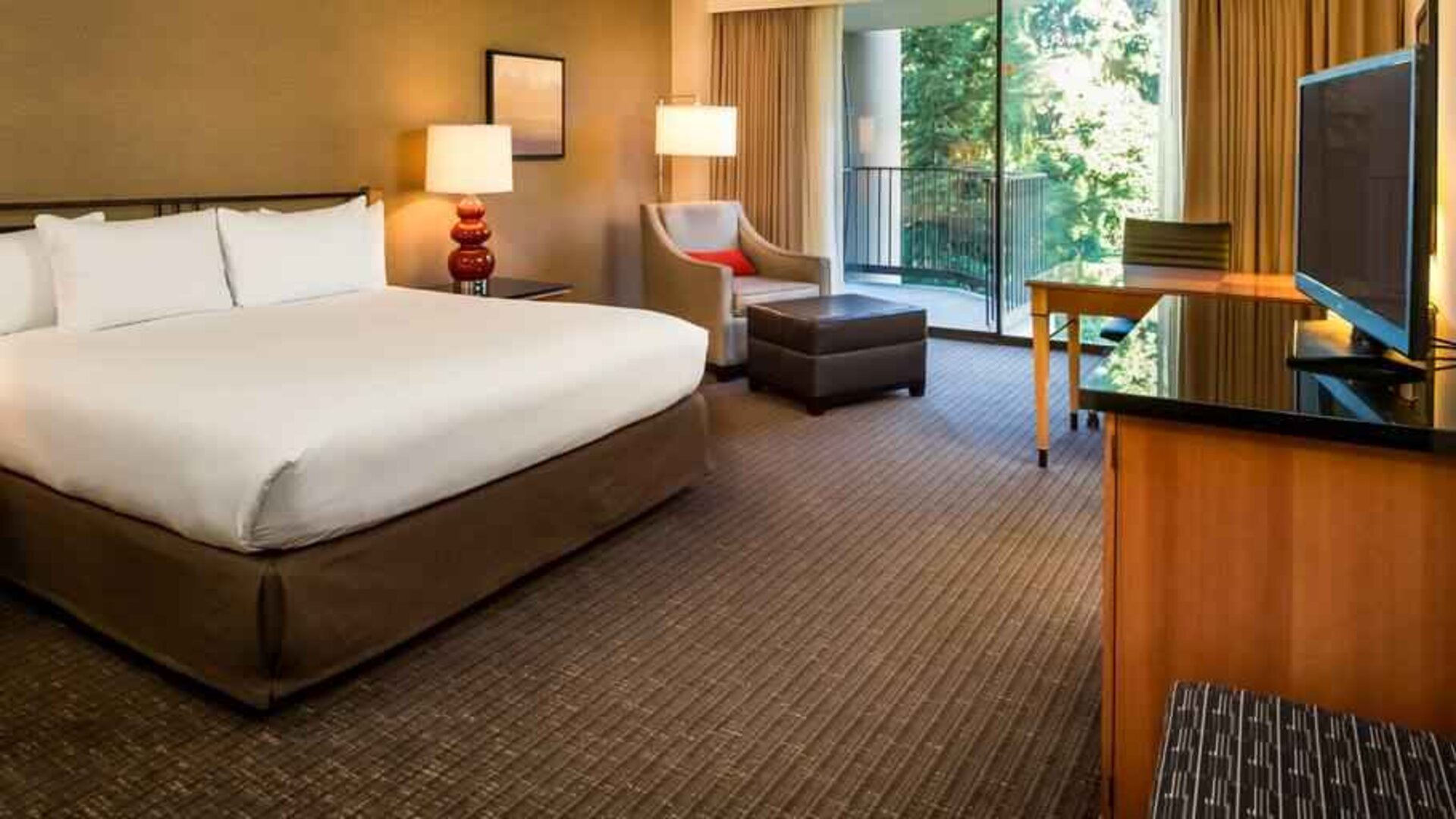 Comfortable king bedroom with balcony at the DoubleTree by Hilton Seattle Airport.