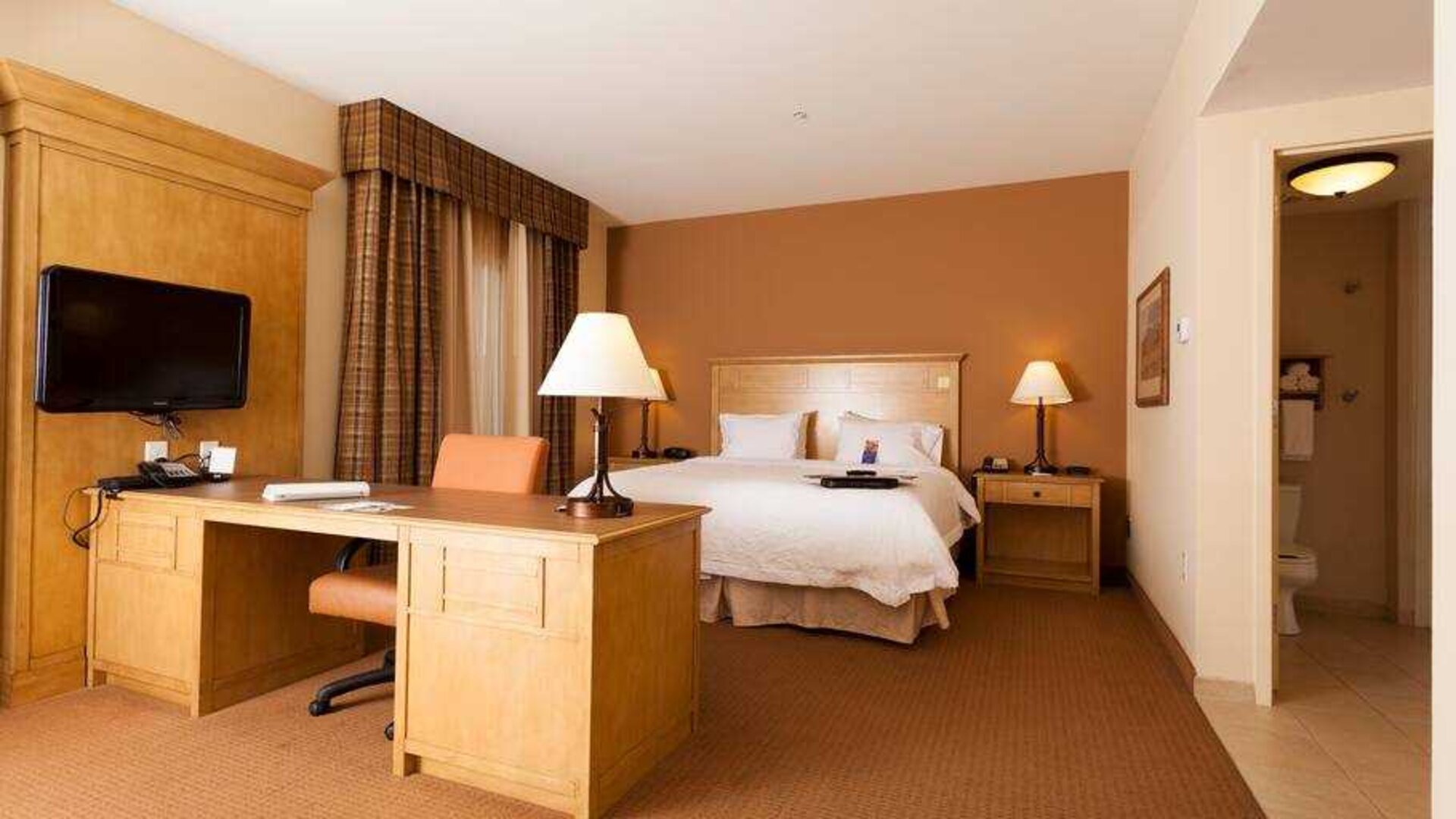 Hotel room with king size bed and working station at the Hampton Inn & Suites Riverton, WY.