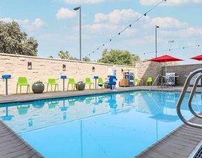 beautiful and large outdoor pool with colorful seating at Home2 Suites by Hilton West Sacramento.