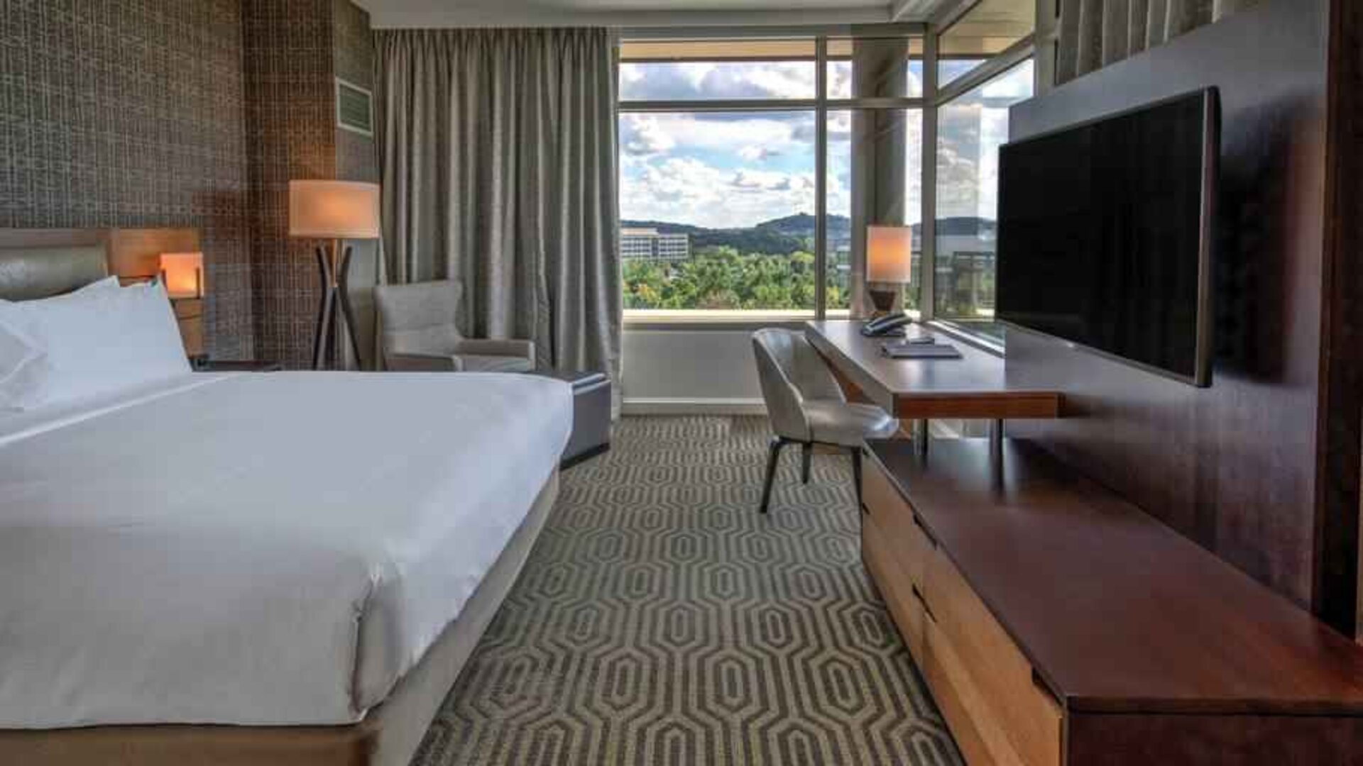 Executive king bedroom with desk, window and TV screen at the Hilton Franklin Cool Springs.