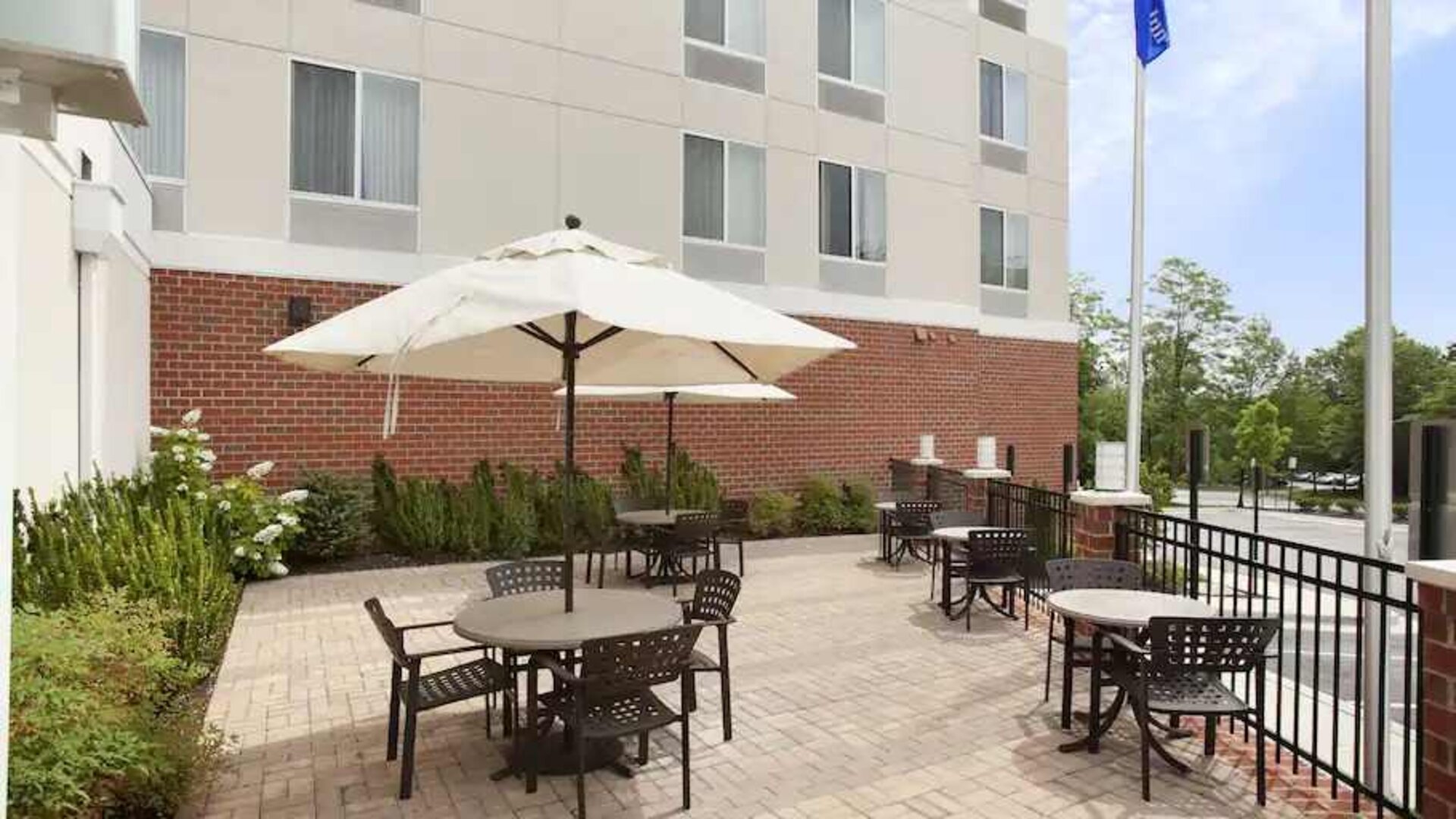 Outdoor patio with tables and chairs perfect as workspace at the Hilton Garden Inn Silver Spring White Oak.