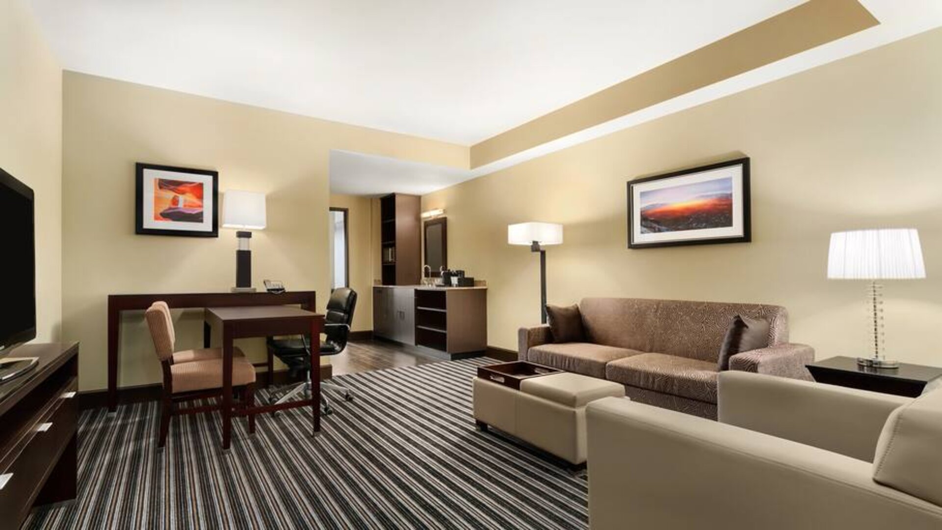 Living room with sofa and desk at the Embassy Suites by Hilton Salt Lake City West Valley.