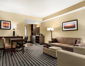 Living room with sofa and desk at the Embassy Suites by Hilton Salt Lake City West Valley.