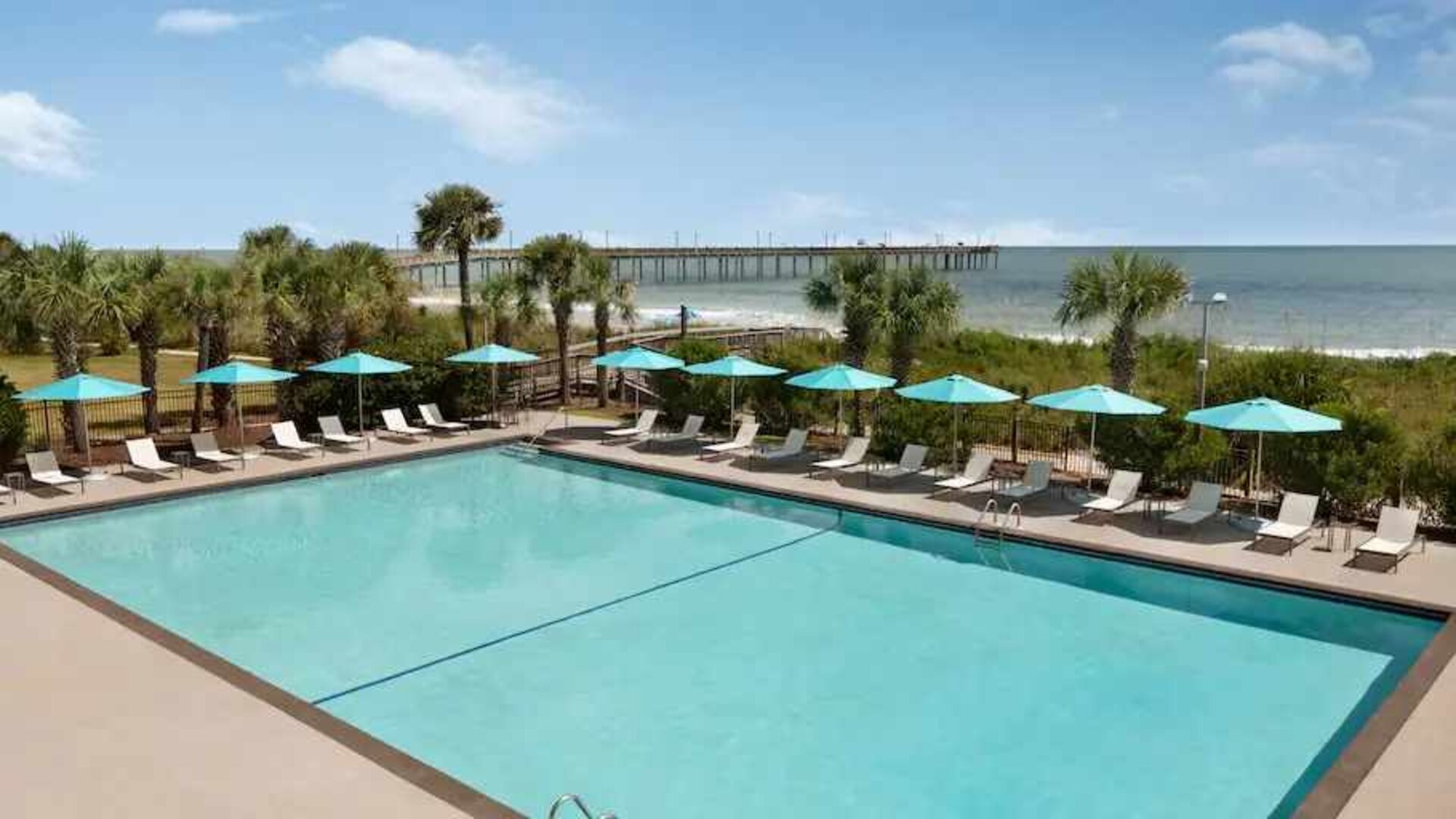 Beautiful outdoor pool area with lounges at the DoubleTree by Hilton Myrtle Beach.