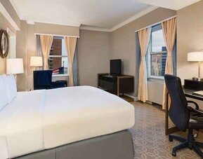 Delux king room with TV, work desk, and natural light at Hilton Milwaukee City Center.