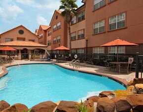 beautiful outdoor pool with sun beds and seating area at Homewood Suites by Hilton Houston-Woodlands.