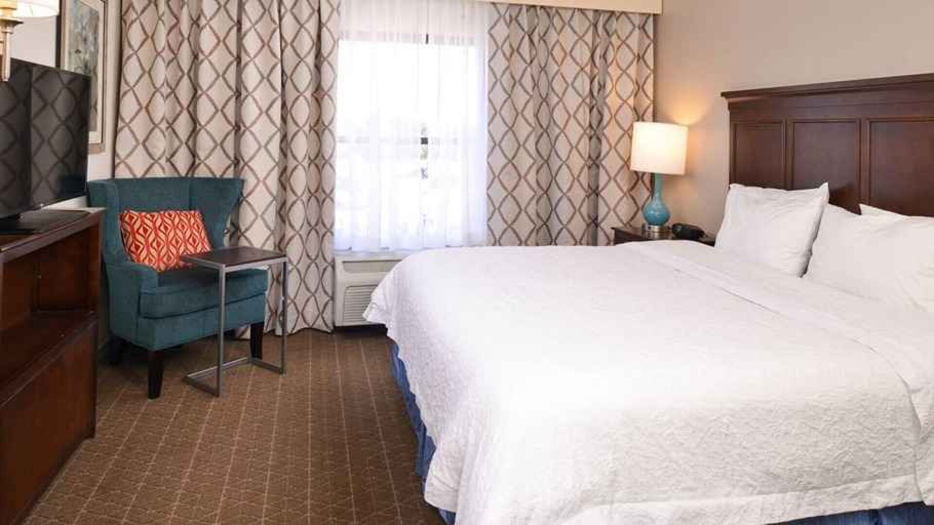 Comfortable king room with TV and work area at Hampton Inn & Suites Pueblo-Southgate.