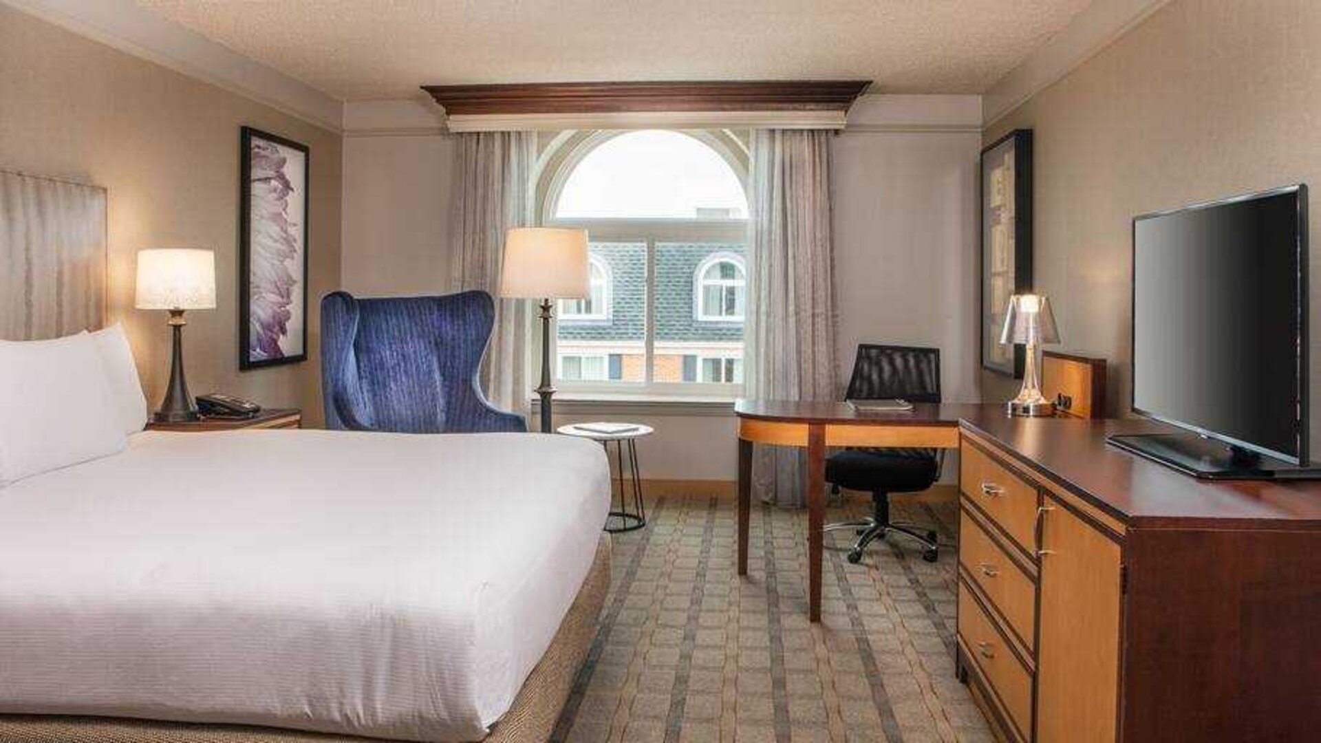 King guestroom with TV screen and desk at the Hilton Wilmington-Christiana.